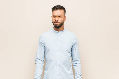 Genç Güney Asyalı iş adamının kafası karışık, kuşkulu ve kararsız..