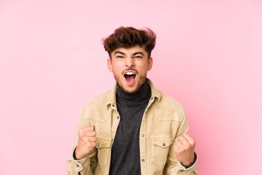 Arka planda poz veren genç bir Arap adam yalnız, gamsız ve heyecanlı. Zafer konsepti.