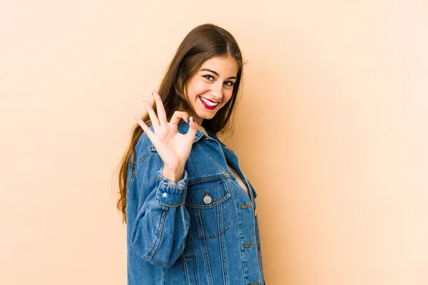 Young Caucasian Woman Isolated Beige Background Winks Eye Holds Okay — Stock Photo, Image