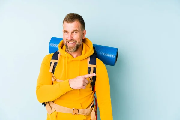 Senior Caminhante Homem Isolado Fundo Azul Sorrindo Apontando Para Lado — Fotografia de Stock