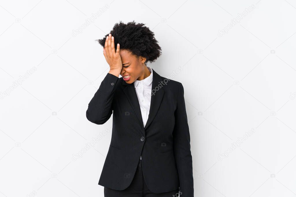Middle aged african american business  woman against a white background isolated forgetting something, slapping forehead with palm and closing eyes.