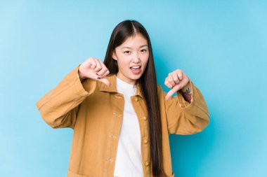 Mavi arka planda poz veren Çinli genç bir kadın..