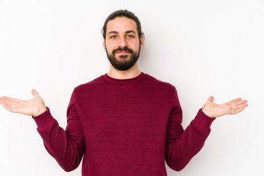 Beyaz arka planda izole edilmiş genç, uzun saçlı adam kollarıyla ölçek yapar, mutlu ve kendinden emin hisseder..