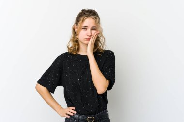 Beyaz arka planda oturan, üzgün ve dalgın hisseden, kopyalama alanına bakan genç beyaz bir kadın..