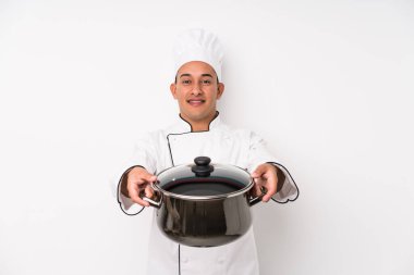 Genç aşçı Latin adam yemek yapıyor.