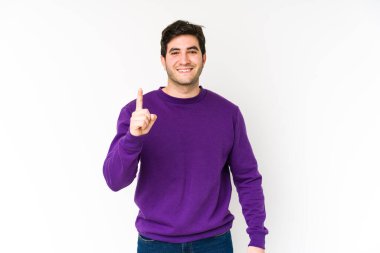 Genç adam beyaz arka planda izole edilmiş. Parmağıyla bir numarayı gösteriyor..
