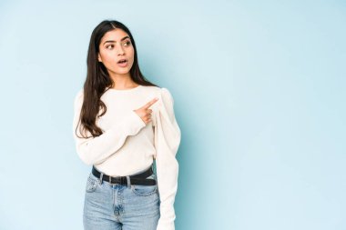 Mavi arka planda izole edilmiş genç Hintli kadın...