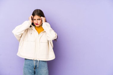 Mor arka planda izole edilmiş beyaz bir kadın ağlıyor, bir şeyden memnun değil, acı ve kafa karışıklığı konsepti..
