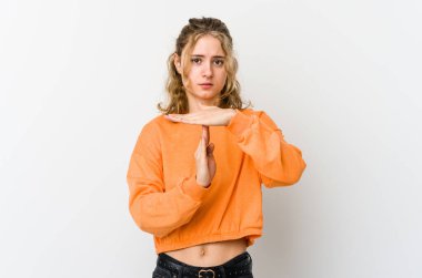 Beyaz arka plandaki genç beyaz kadın bir mola hareketi gösteriyor..