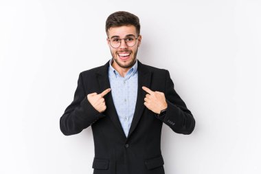 Beyaz arka planda poz veren beyaz tenli genç beyaz iş adamı genç beyaz iş adamını parmağıyla işaret ederek şaşırttı, geniş bir gülümsemeyle..