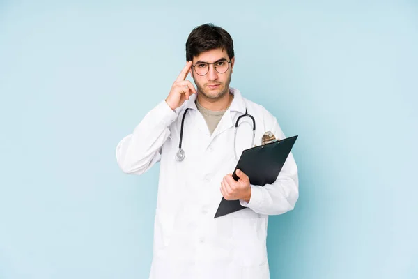 Junger Arzt Isoliert Auf Blauem Hintergrund Zeigt Mit Dem Finger — Stockfoto