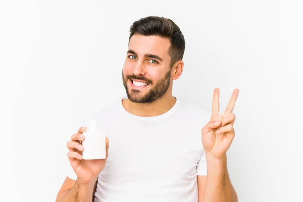 Mladý Běloch Drží Láhev Vitamíny Izolované Ukazující Číslo Dvě Prsty — Stock fotografie