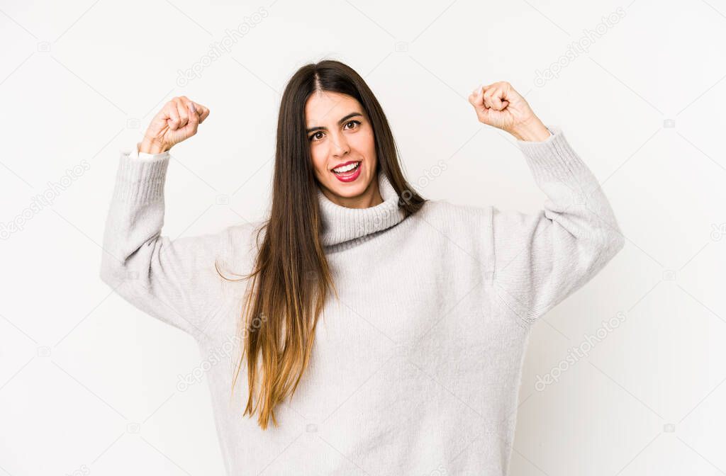 Young caucasian woman isolated on a white background showing strength gesture with arms, symbol of feminine power