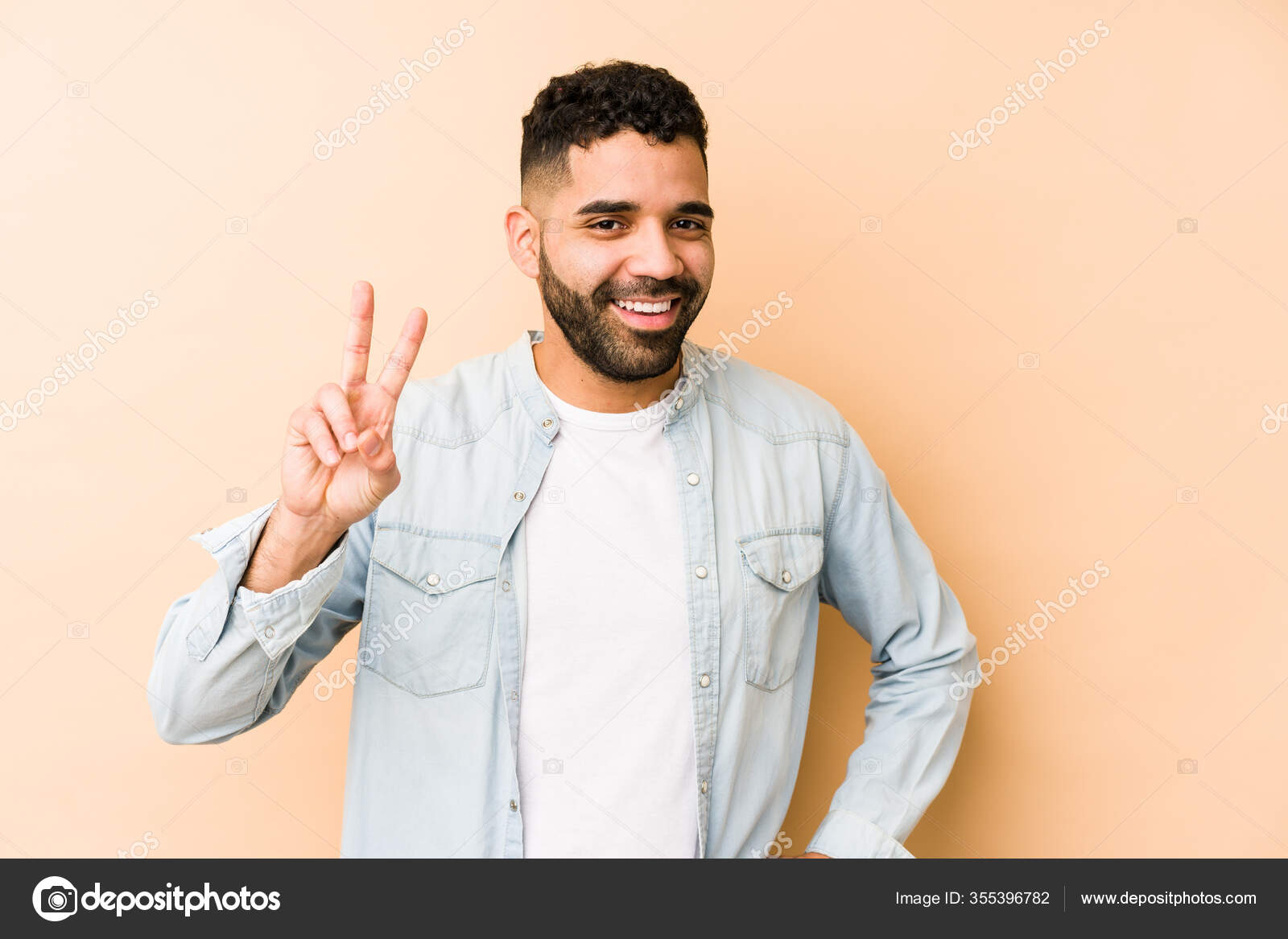 Young Mixed Race Arabic Man Isolated Showing Victory Sign Smiling Stock Photo by