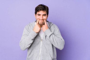 Mor arka planda iki seçenek arasındaki şüpheyle izole edilmiş genç adam.