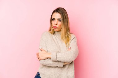 Orta yaşlı bir kadın soyutlanmış arka planda hoşnutsuzca kaşlarını çatmış, kollarını kavuşturmuş..