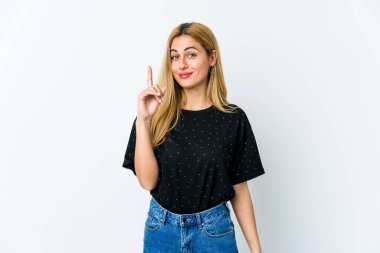 Beyaz arka planda izole edilmiş genç sarışın kadın bir numarayı parmağıyla gösteriyor..