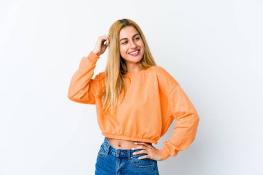 Genç sarışın kadın beyaz arka planda izole edilmiş zaferi, tutkuyu ve coşkuyu kutluyor, mutlu bir ifade..