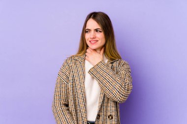 Kafkasyalı genç bir kadın mor arka planda izole edilmiş kafasının arkasına dokunuyor, düşünüyor ve bir seçim yapıyor..