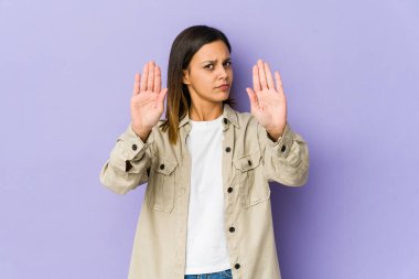 Mor arka planda izole edilmiş genç bir kadın elini uzatmış, dur işareti göstererek seni engelliyor..