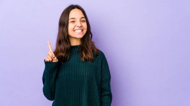 Genç, melez, Latin bir kadın bir numarayı parmağıyla gösteriyor..