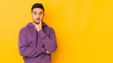 Kafkasyalı genç adam sarı fırında izole edilmiş şüpheli ve şüpheci bir ifadeyle yana bakıyor..