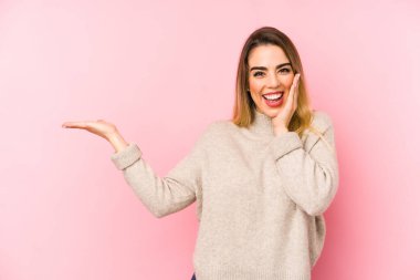 Arka planda izole edilmiş orta yaşlı bir kadın avuç içinde fotokopi alanı tutuyor, el üstünde tutuyor. Şaşırmış ve mutlu..