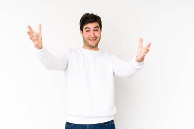 Genç adam beyaz arka planda zaferi ya da başarıyı kutlarken şaşırdı ve şok oldu..