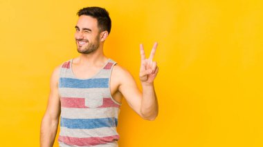 Sarı fırında izole edilmiş genç beyaz adam iki numarayı parmaklarıyla gösteriyor..