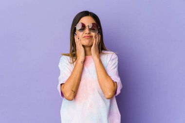 Mor arka planda izole edilmiş genç hippi kadın ağlıyor, bir şeyden memnun değil, acı ve kafa karışıklığı konsepti..