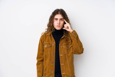 Uzun saçlı adam kendini soyutlamış, parmağıyla işaret ediyor, düşünüyor ve bir göreve odaklanıyor..