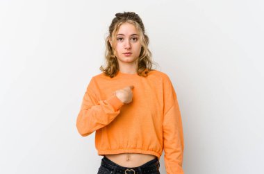 Beyaz arka plandaki genç beyaz kadın parmağını gösterip gülümseyerek şaşırdı..