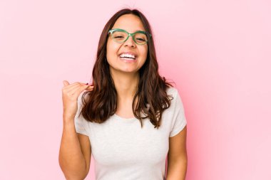 Latin kökenli genç bir kadın bir şeylere gülüyor, elleriyle ağzını kapatıyor..