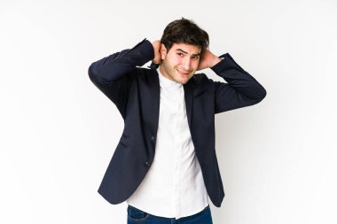 Genç iş adamı beyaz arka planda izole edilmiş kafasının arkasına dokunuyor, düşünüyor ve bir seçim yapıyor..