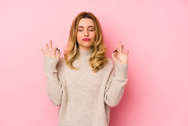 Süveter giyen genç sarışın kadın sıkı çalışma gününden sonra rahatlıyor, yoga yapıyor..