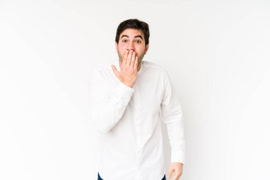 Beyaz arka planda izole edilmiş genç adam şok olmuş, ağzı ellerle kaplanmış, yeni bir şey keşfetmeye hevesli..