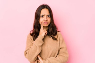 Latin kökenli genç bir kadın şüpheli ve şüpheci bir ifadeyle yanlamasına bakıyor..