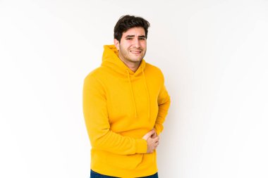 Beyaz arka planda karaciğer ağrısı ve karın ağrısı olan genç bir adam..