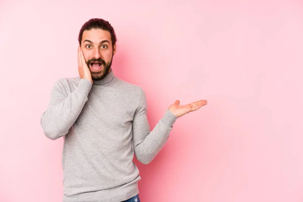 Young Long Hair Man Isolated Pink Background Holds Copy Space — Stock Photo, Image