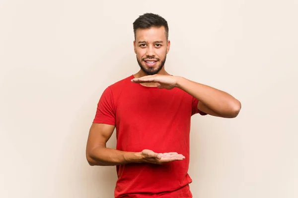 Joven Hombre Sudasiático Sosteniendo Algo Con Ambas Manos Presentación Del —  Fotos de Stock