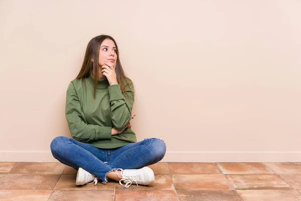 Young Caucasian Woman Sitting Floor Isolated Looking Sideways Doubtful Skeptical — ストック写真