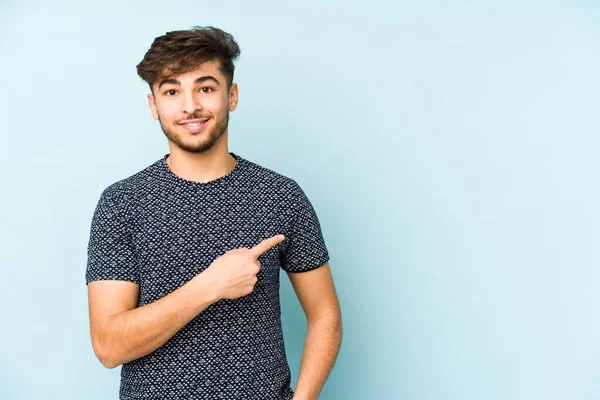 Jonge Arabische Man Geïsoleerd Een Blauwe Achtergrond Glimlachend Terzijde Wijzend — Stockfoto