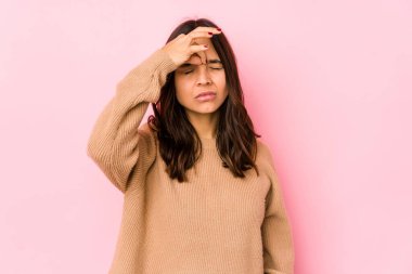 Genç, melez İspanyol bir kadın izole edilmiş, başı ağrıyor, yüzüne dokunuyor..