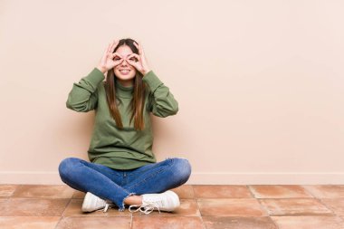 Yerde tek başına oturan beyaz bir kadın. Gözlerinin üzerinde iyi bir işaret var.