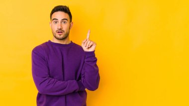 Kafkasyalı genç adam sarı fırında izole edilmiş, harika bir fikri var, yaratıcılık kavramı..