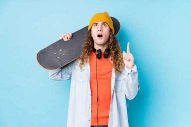Kafkasyalı genç kaykaycı, izole edilmiş, ağzı açık, üst tarafı işaret ediyor..