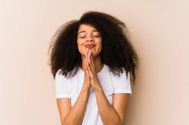 Genç Afro-Amerikalı kadın el ele tutuşup dua ediyor, kendinden emin..