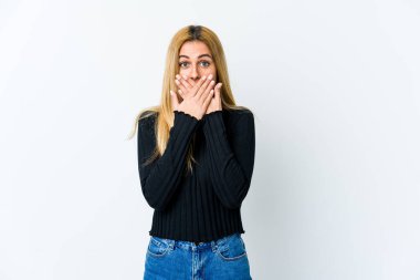 Beyaz arka planda izole edilmiş genç sarışın kadın elleriyle ağzını kapatırken şok oldu..