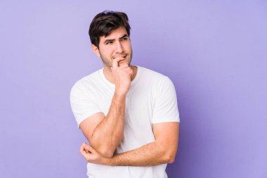 Mor arka planda izole edilmiş genç adam rahatlamış fotokopi odasına bakan bir şey düşünüyor..