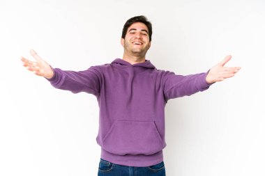 Beyaz arka planda izole edilmiş genç adam kameraya sarıldığı için kendinden emin hissediyor..